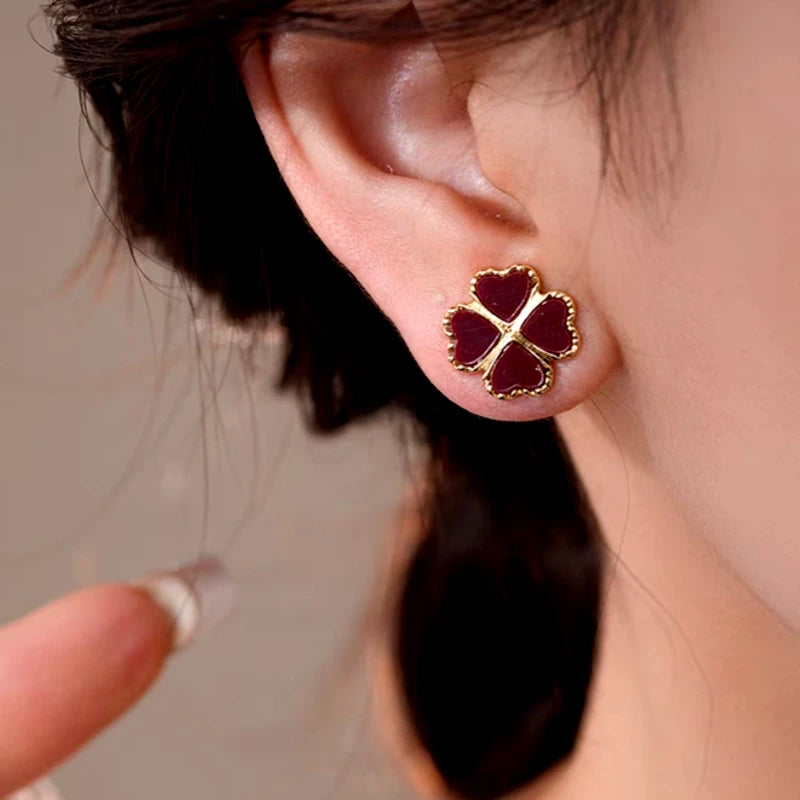 Model showcasing the dangle and style of the 14K Gold-Plated Elegant Four-Leaf Stud Earrings