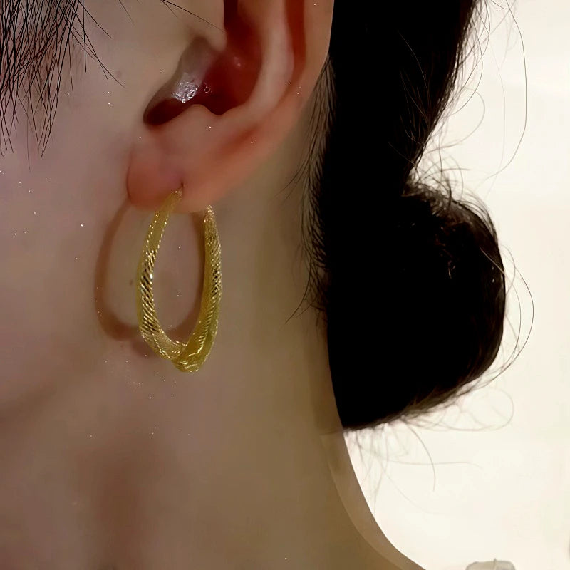 Model showcasing the dangle and style of the 14K Gold-Plated Elegant Front And Back Cross Earrings