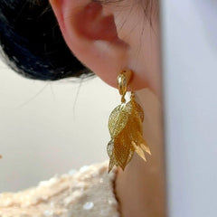 Model showcasing the dangle and style of the 14K Gold-Plated Elegant Golden Leaf Tassel Earrings