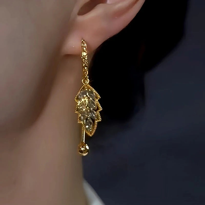 Model showcasing the dangle and style of the 14K Gold-Plated Elegant Gray Diamond Leaf Earrings