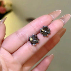 Model showcasing the dangle and style of the 14K Gold-Plated Elegant Gray Petal Flower Stud Earrings