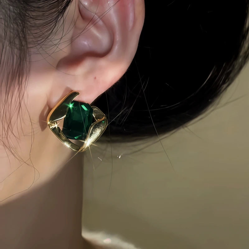 Model showcasing the dangle and style of the 14K Gold-Plated Elegant Green Crystal Earrings