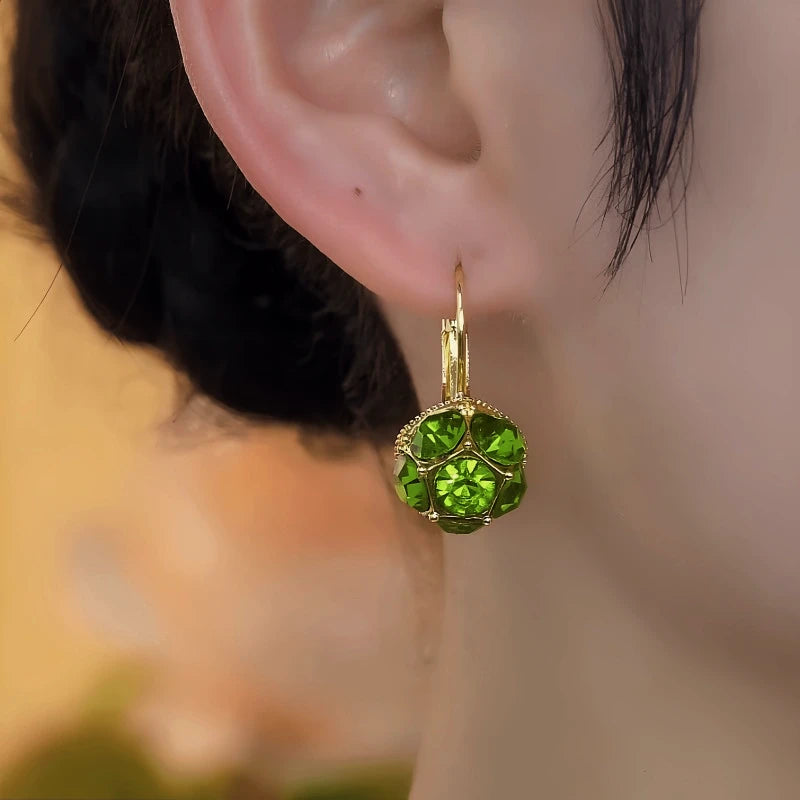 Model showcasing the dangle and style of the 14K Gold-Plated Elegant Green Diamond Crystal Earrings