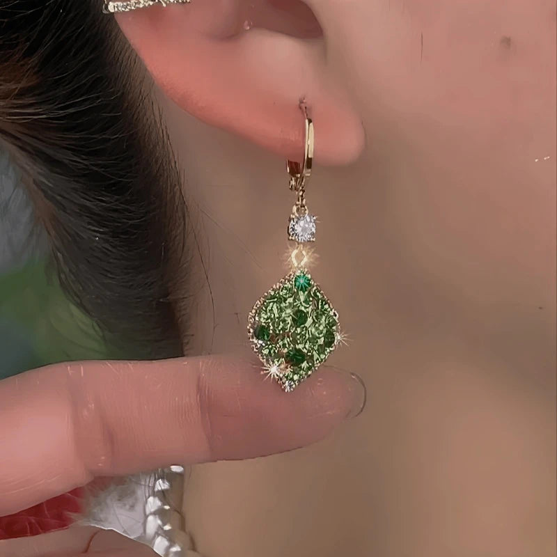 Model showcasing the dangle and style of the 14K Gold-Plated Elegant Green Diamond Water Drop Earrings