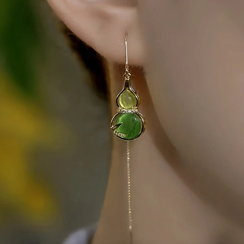 Model showcasing the dangle and style of the 14K Gold-Plated Elegant Green Gourd Threader Earrings