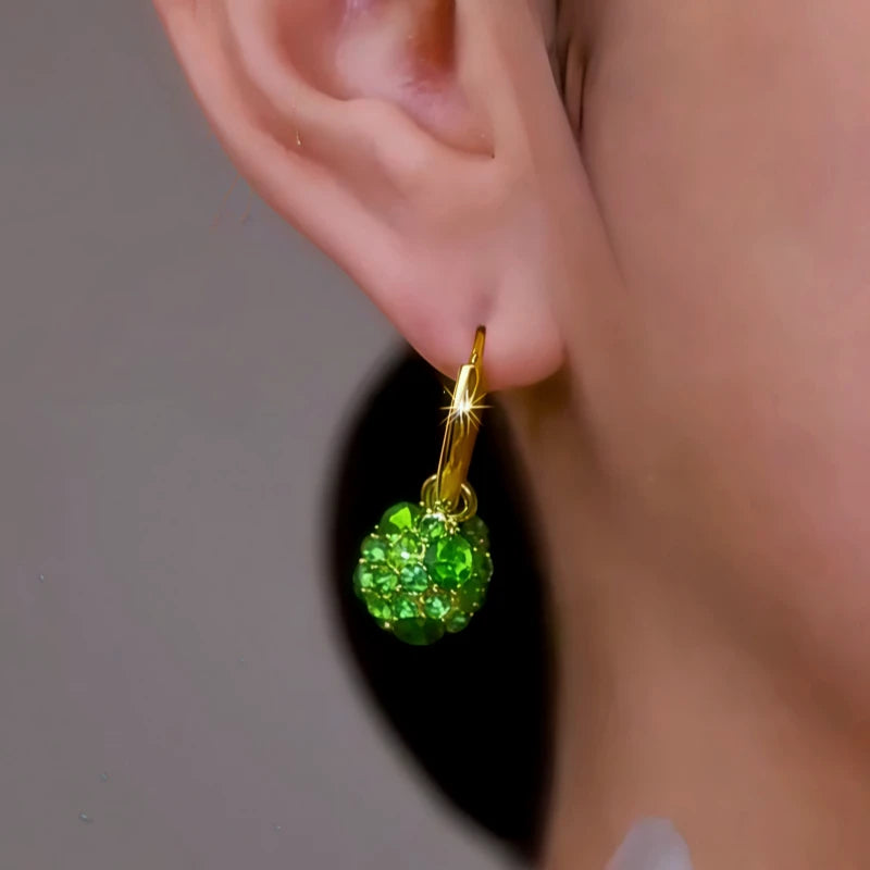 Model showcasing the dangle and style of the 14K Gold-Plated Elegant Green Zircon Ball Earrings