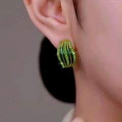 Model showcasing the dangle and style of the 14K Gold-Plated Elegant Green Zircon Line Stud Earrings