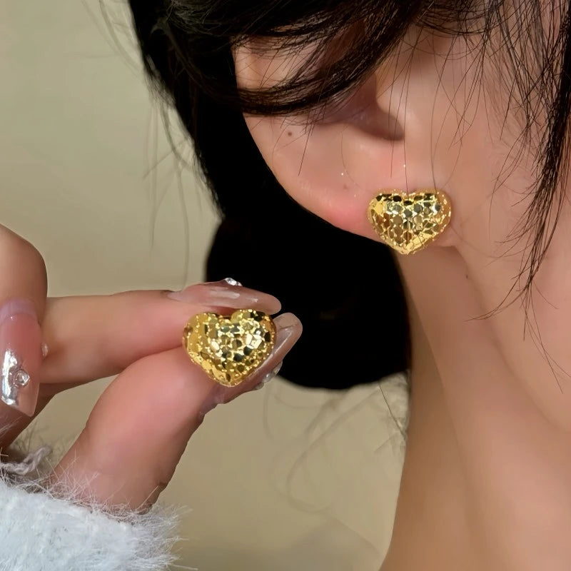 Model showcasing the dangle and style of the 14K Gold-Plated Elegant Heart Studs