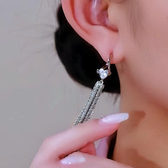 Model showcasing the dangle and style of the 14K Gold-Plated Elegant Heart Tassel Earrings