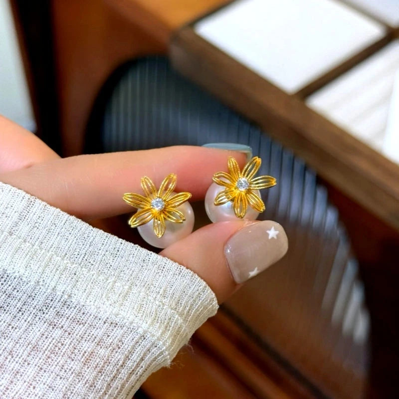 Model showcasing the dangle and style of the 14K Gold-Plated Elegant Hollow Flower Pearl Jacket Earrings