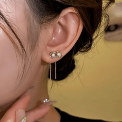 Model showcasing the dangle and style of the 14K Gold-Plated Elegant Hollow Flower Pearl Threader Earrings