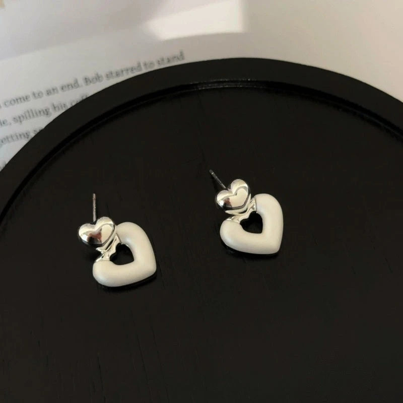 Model showcasing the dangle and style of the 14K Gold-Plated Elegant Hollow Heart Earrings