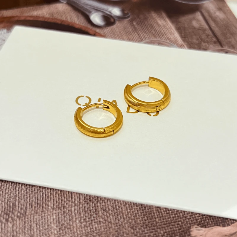 Model showcasing the dangle and style of the 14K Gold-Plated Elegant Hoop Earrings