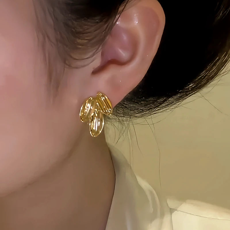 Model showcasing the dangle and style of the 14K Gold-Plated Elegant Leaf Stud Earrings