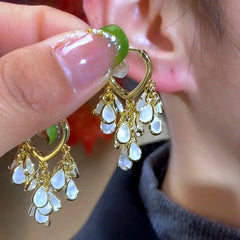 Model showcasing the dangle and style of the 14K Gold-Plated Elegant Leaf Tassel Earrings