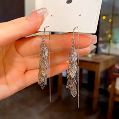 Model showcasing the dangle and style of the 14K Gold-Plated Elegant Leaf Tassel Threader Earrings