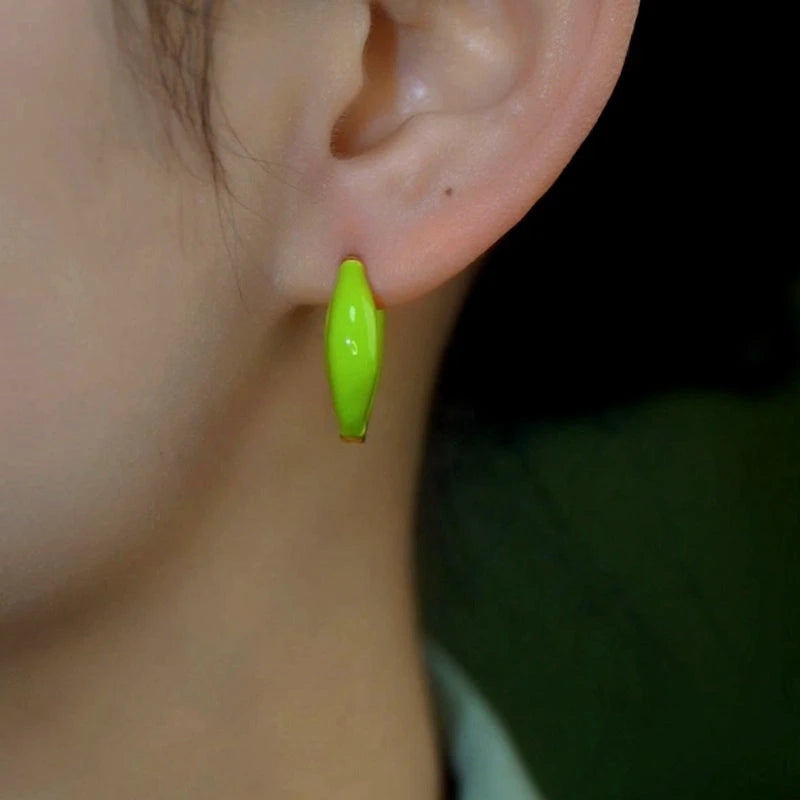 Model showcasing the dangle and style of the 14K Gold-Plated Elegant Light Green Oil Drop Little Hoop Earrings