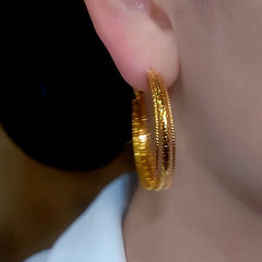 Model showcasing the dangle and style of the 14K Gold-Plated Elegant Multi-Layer Hoop Earrings