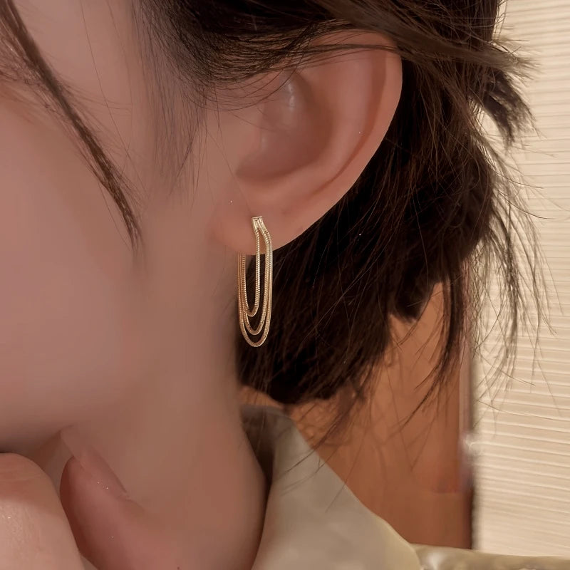 Model showcasing the dangle and style of the 14K Gold-Plated Elegant Multi-Layer Tassel Earrings
