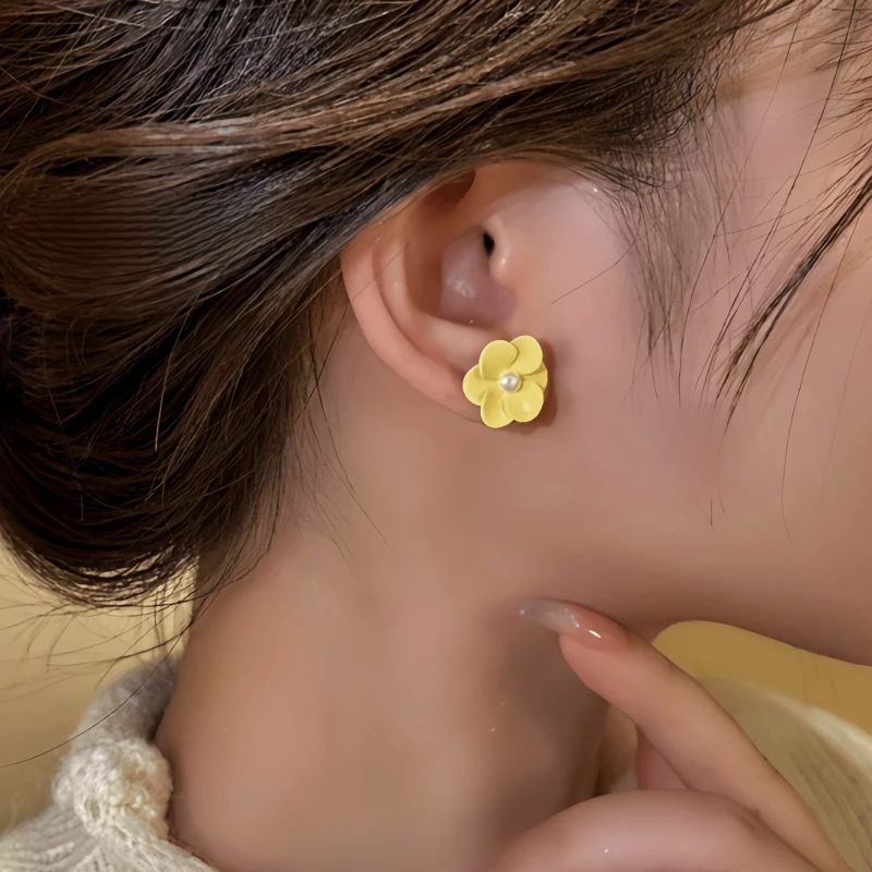 Model showcasing the dangle and style of the 14K Gold-Plated Elegant Pale Yellow Flower Stud Earrings