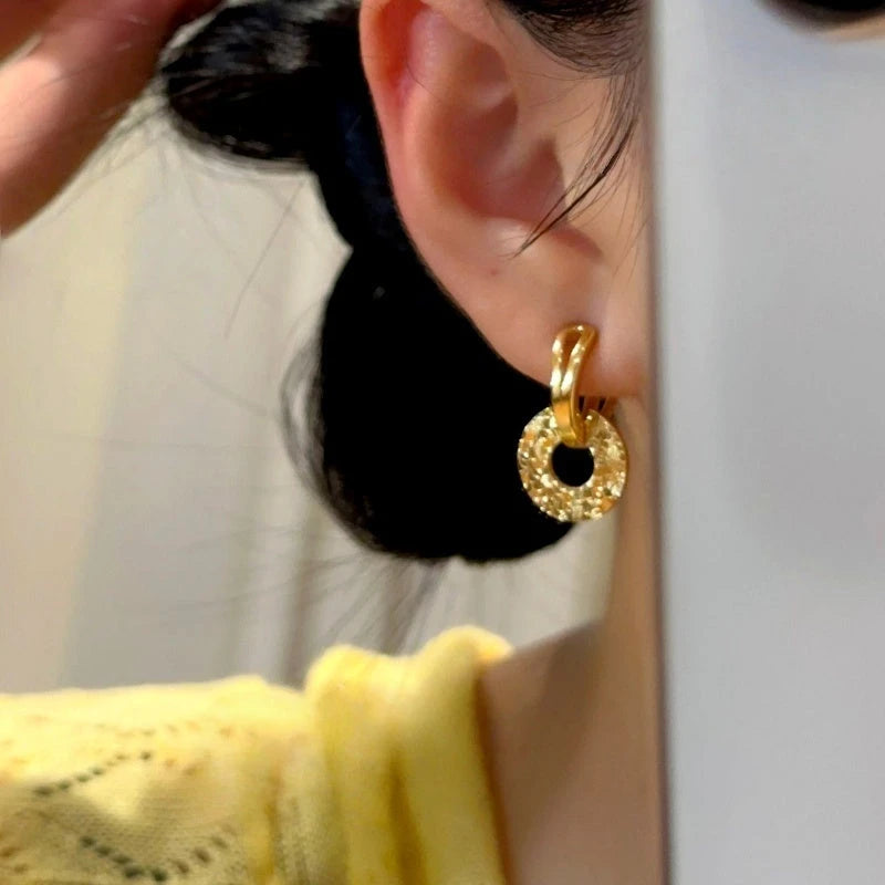 Model showcasing the dangle and style of the 14K Gold-Plated Elegant Peace Locket Shattered Ice Earrings