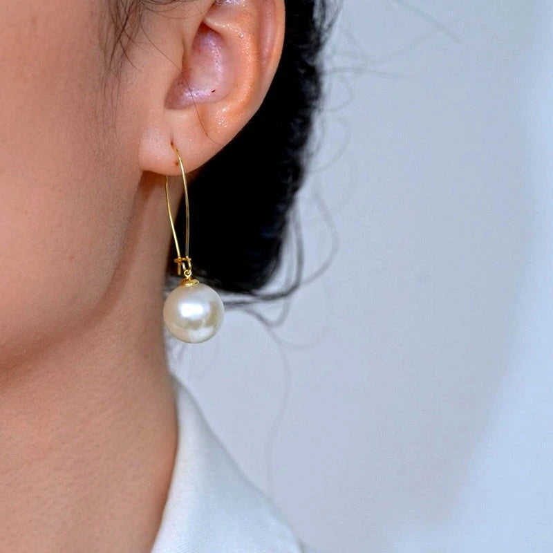 Model showcasing the dangle and style of the 14K Gold-Plated Elegant Pearl Earrings