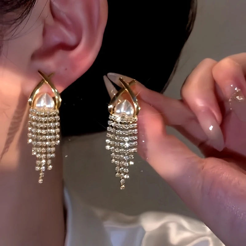 Model showcasing the dangle and style of the 14K Gold-Plated Elegant Pearl Heart Zircon Tassel Earrings