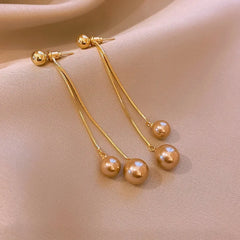 Angled view of the 14K Gold-Plated Elegant Pearl Tassel Earrings