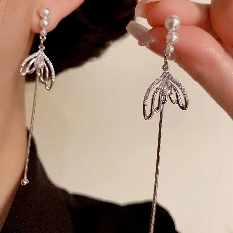 Model showcasing the dangle and style of the 14K Gold-Plated Elegant Pearl Zircon Fishtail Tassel Earrings