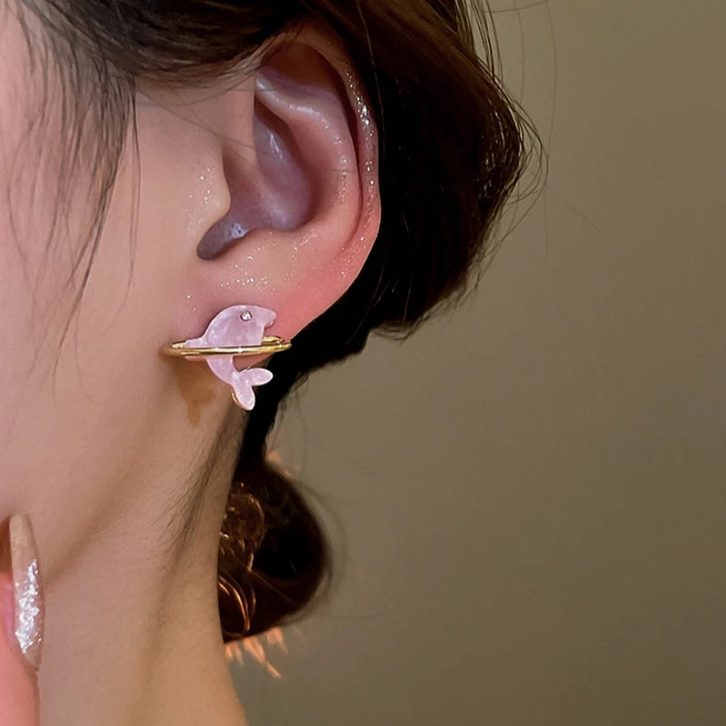Model showcasing the dangle and style of the 14K Gold-Plated Elegant Pink Dolpin Stud Earrings