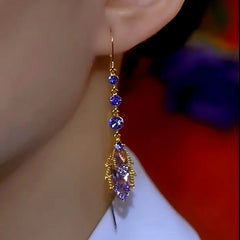 Model showcasing the dangle and style of the 14K Gold-Plated Elegant Purple Crystal Diamond Tassel Earrings