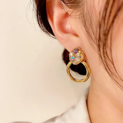 Model showcasing the dangle and style of the 14K Gold-Plated Elegant Purple Diamond Flower Pearl Hoop Earrings