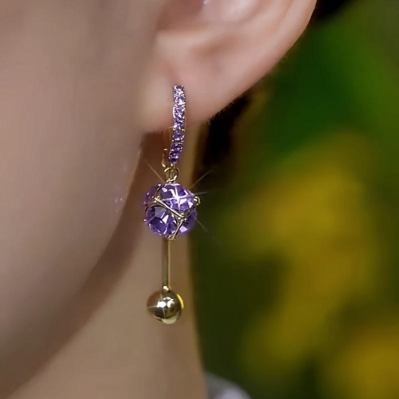 Model showcasing the dangle and style of the 14K Gold-Plated Elegant Purple Zircon Diamond Tassel Earrings