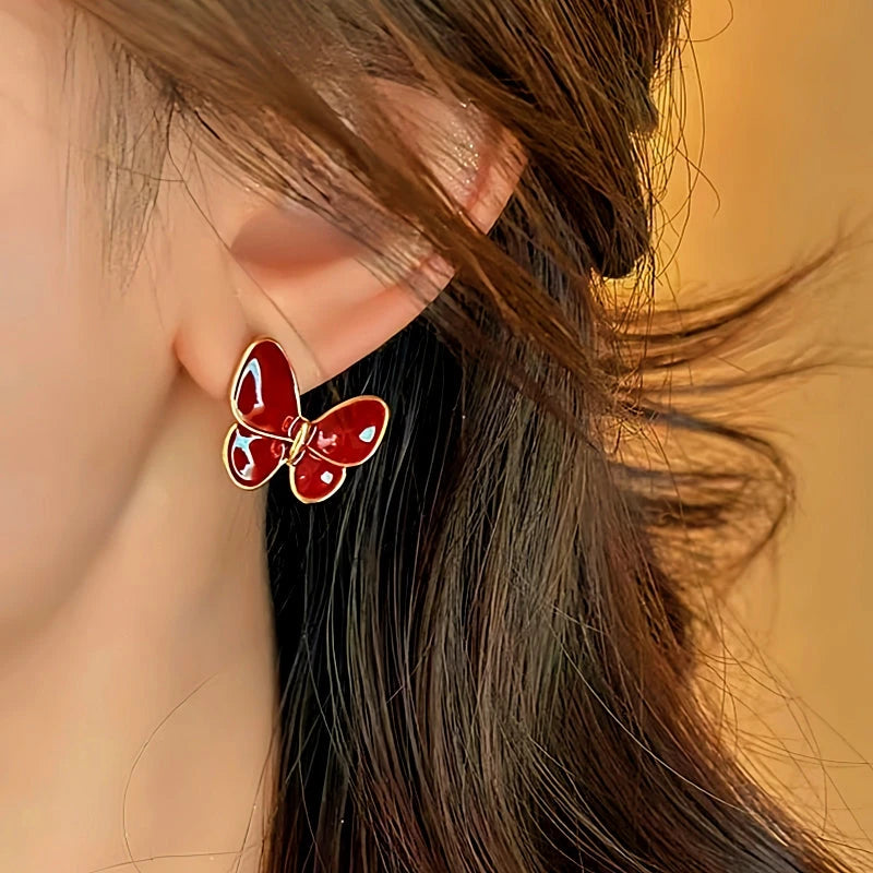 Model showcasing the dangle and style of the 14K Gold-Plated Elegant Red Butterfly Earrings
