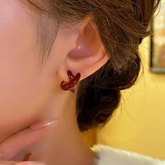 Model showcasing the dangle and style of the 14K Gold-Plated Elegant Red Cross Irregular Earrings