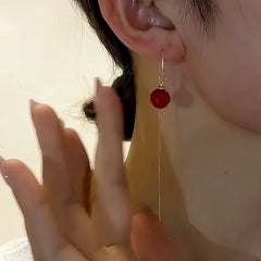 Model showcasing the dangle and style of the 14K Gold-Plated Elegant Red Crystal Ball Threader Earrings
