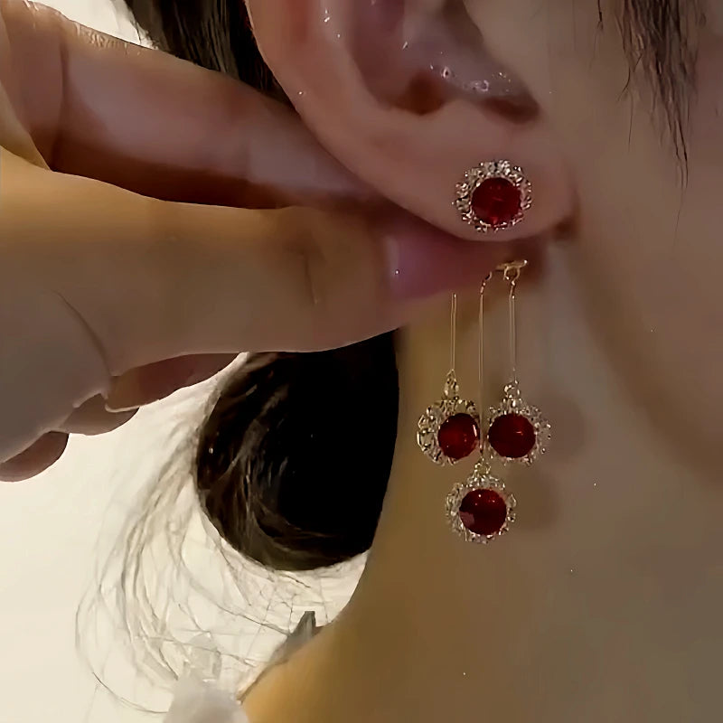 Model showcasing the dangle and style of the 14K Gold-Plated Elegant Red Crystal Tassel Earrings