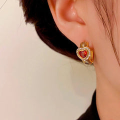 Model showcasing the dangle and style of the 14K Gold-Plated Elegant Red Heart Hoop Earrings