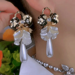 Model showcasing the dangle and style of the 14K Gold-Plated Elegant Shell Flower Pearl Water Drop Earrings