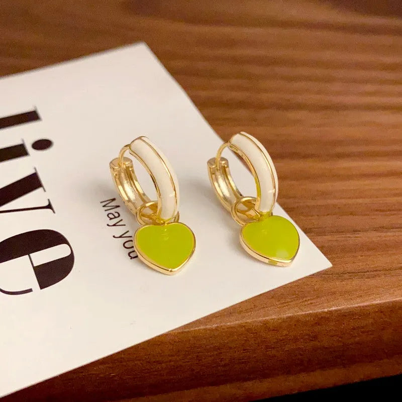 Model showcasing the dangle and style of the 14K Gold-Plated Elegant Simple And Gentle Drip Glaze Heart Earrings