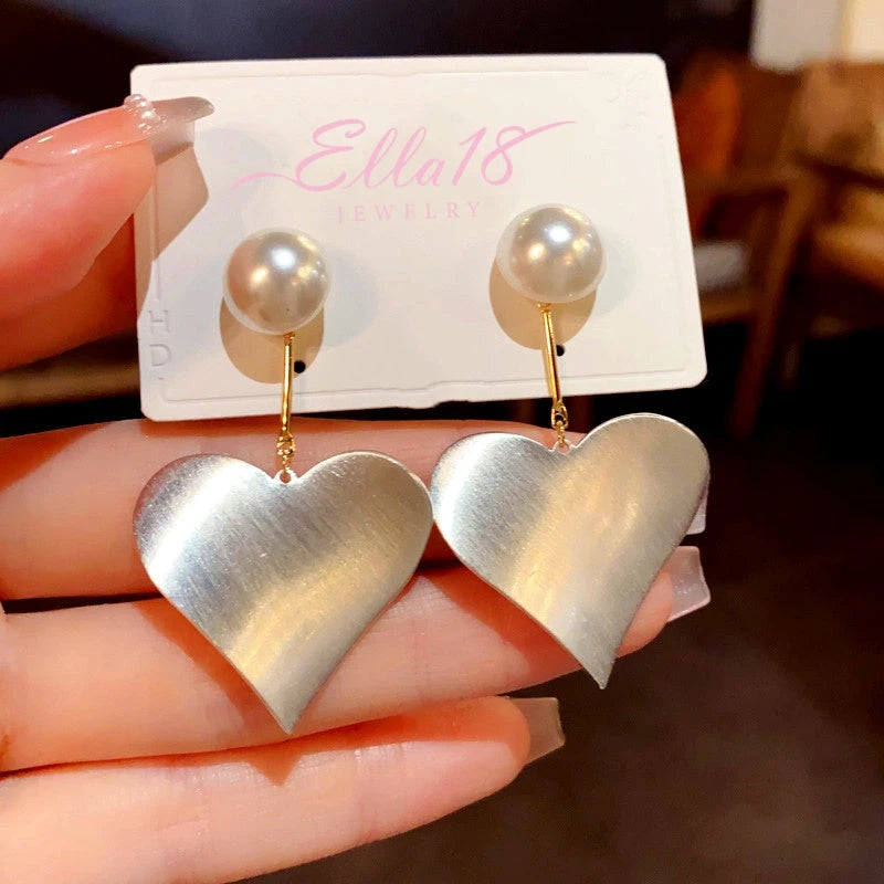 Angled view of the 14K Gold-Plated Elegant Simple Exaggerated Metal Heart Pearl Earrings