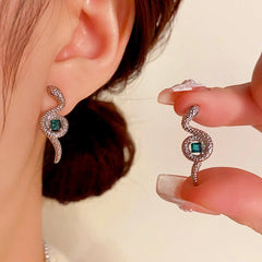 Model showcasing the dangle and style of the 14K Gold-Plated Elegant Snake-Shaped Green Square Diamond Earrings