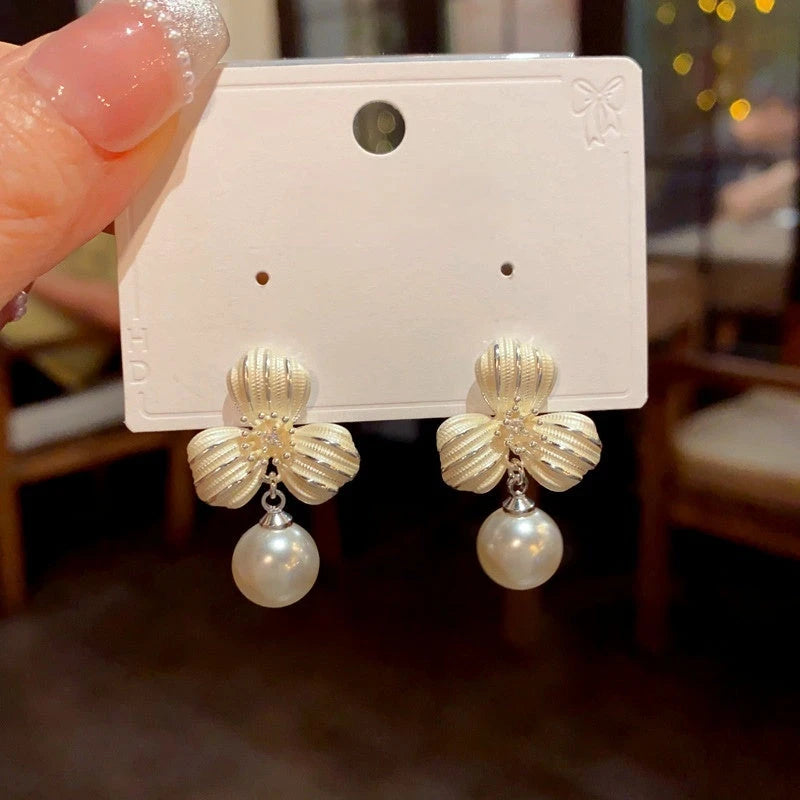 Close-up detail of the sparkling zircons and plating on the Clover Pearl Earrings