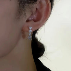 Close-up detail of the sparkling zircons and plating on the Heart Pearl Earrings
