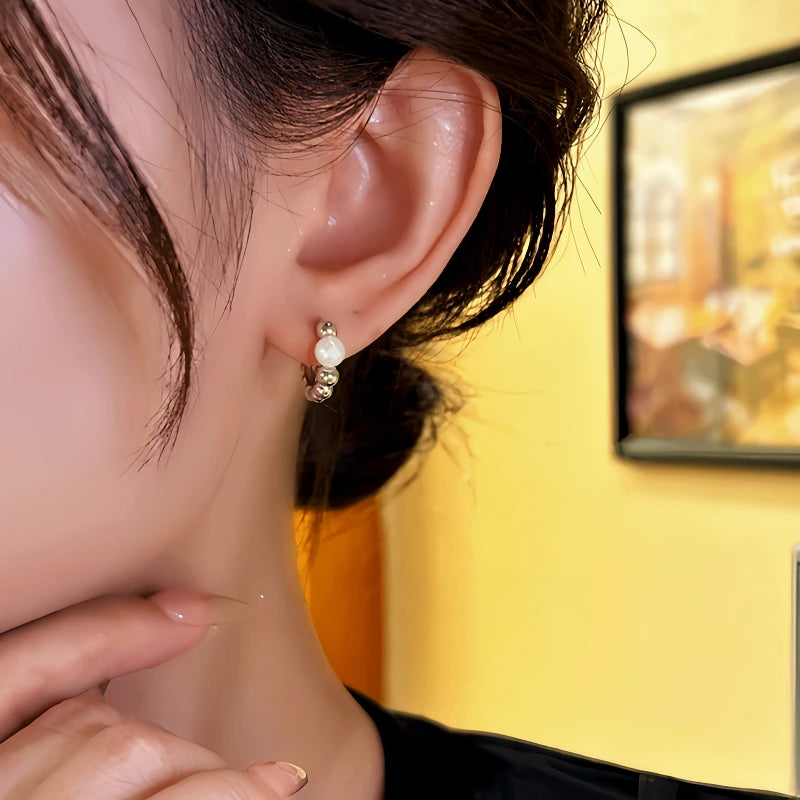 Model showcasing the dangle and style of the 14K Gold-Plated Elegant Twisted Bead Hoop Earrings