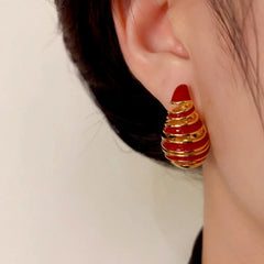 Model showcasing the dangle and style of the 14K Gold-Plated Elegant Water Drop Oil Spiral Earrings