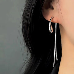 Model showcasing the dangle and style of the 14K Gold-Plated Elegant Water Drop Tassel Earrings
