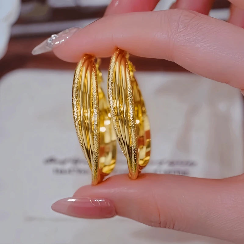 Angled view of the 14K Gold-Plated Elegant Winding Hoop Earrings