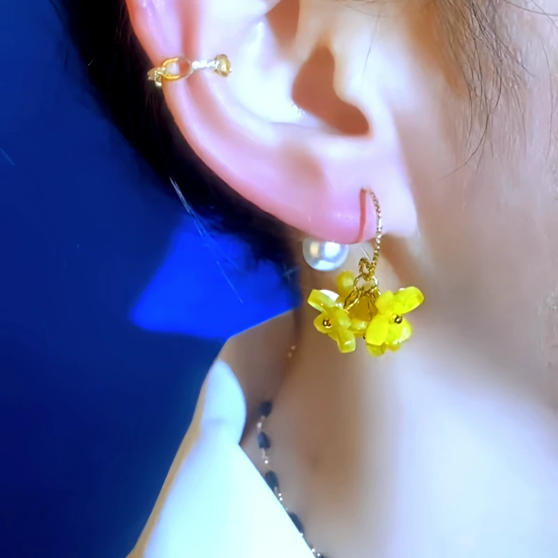 Model showcasing the dangle and style of the 14K Gold-Plated Elegant Yellow Flower Pearl Earrings