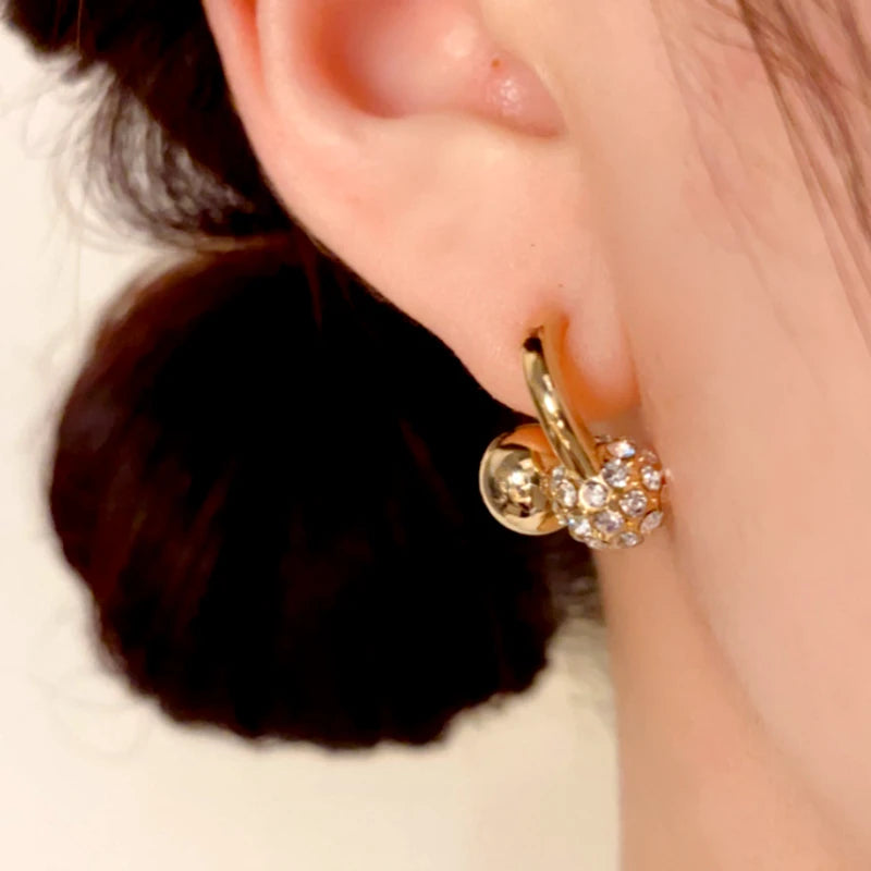 Model showcasing the dangle and style of the 14K Gold-Plated Elegant Zircon Ball Cross Earrings